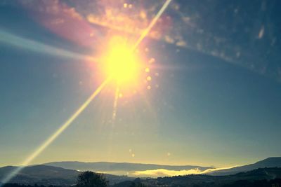 Scenic view of mountains against bright sun