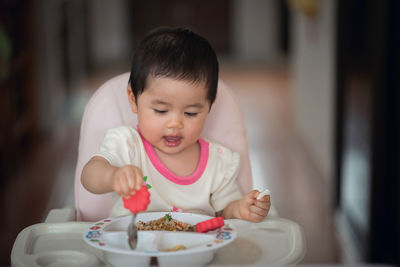 Cute girl eating food in plate