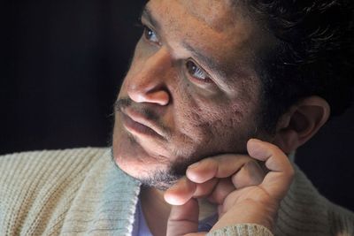 Close-up of thoughtful mid adult man looking away against black background