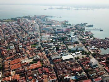 High angle view of townscape by sea against sky