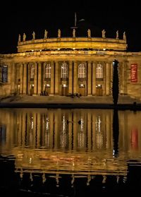 Reflection of illuminated building in water at night