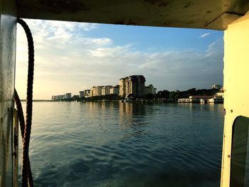 Cityscape by sea against sky seen from doorway