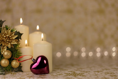 Close-up of christmas decorations with candles on table