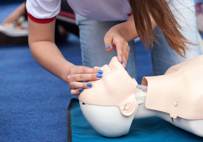 Low section of paramedic examining cpr dummy