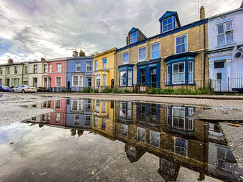 Reflection of building in canal against sky