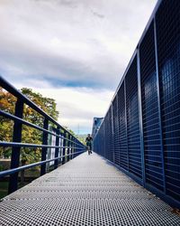 Rear view of man walking on footbridge