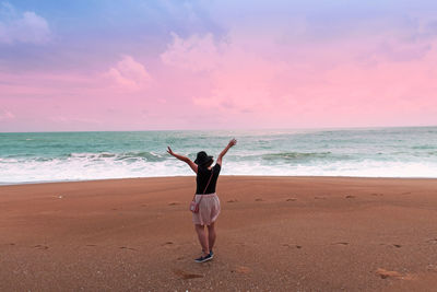 Full length rear view of woman walking on beach