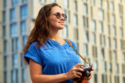 Young woman photographing with camera