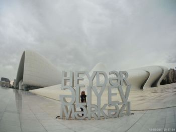 Man in modern building against sky in city