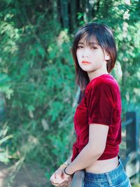 Portrait of a teenage girl standing against trees