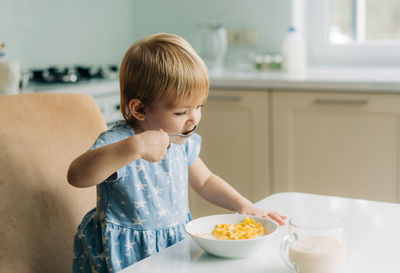 Close-up of cute girl eating food at home