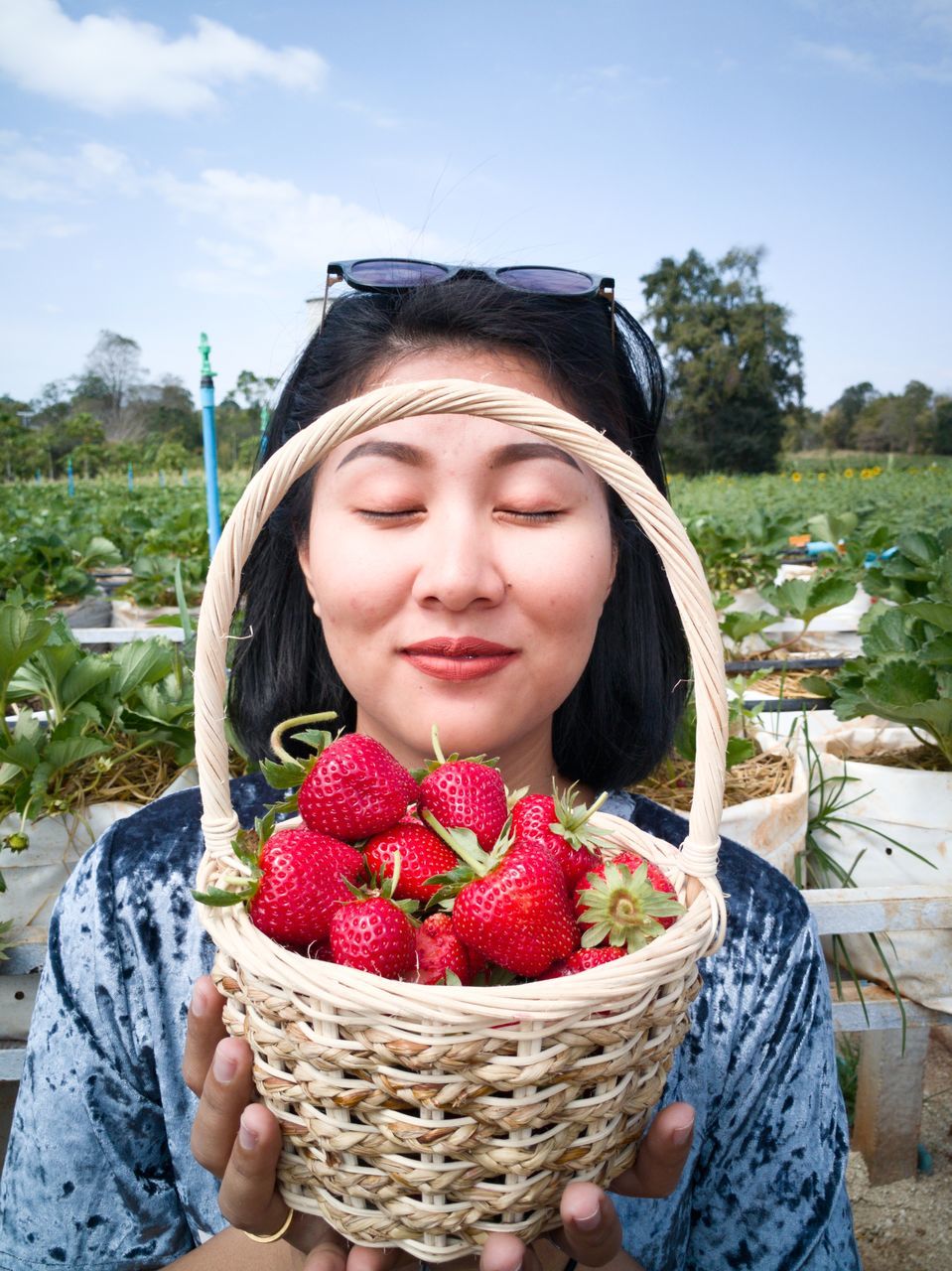 PORTRAIT OF WOMAN IN FIELD WITH RED UMBRELLA