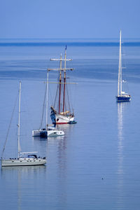 Sailboat sailing on sea against blue sky