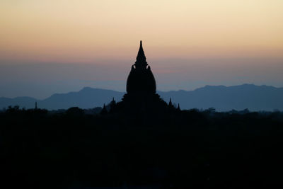 Silhouette of pagoda against sky during sunset