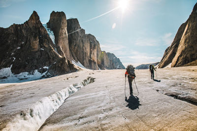 People on rocks against mountains