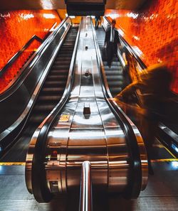 Blurred motion of people on escalator at subway station