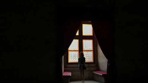 Woman walking against window at home