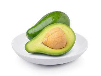 Close-up of green fruit against white background