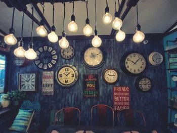 Low angle view of illuminated pendant lights hanging on ceiling in building
