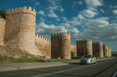 Castle by road against sky