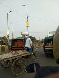 Rear view of man riding bicycle on road