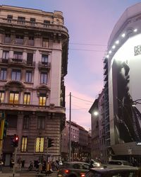 Cars on city street and buildings at dusk