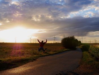 Man on field against sky during sunset