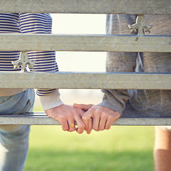 Low section of woman sitting on railing