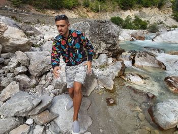 High angle view of young man standing by rock