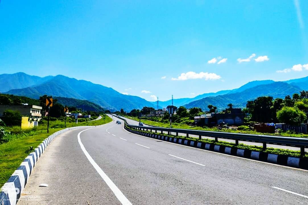 EMPTY ROAD LEADING TOWARDS MOUNTAINS AGAINST BLUE SKY