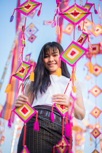 Portrait of smiling woman holding colorful decorations