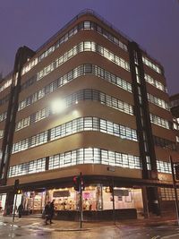 Low angle view of office building against sky at night