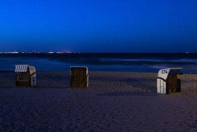 Scenic view of beach against clear blue sky at night