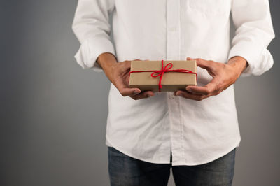 Midsection of man holding box against white background