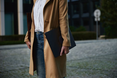 Business woman walking at city street with laptop at summer day. remote work