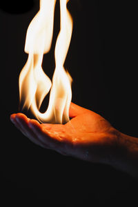 Close-up of lit candle against black background