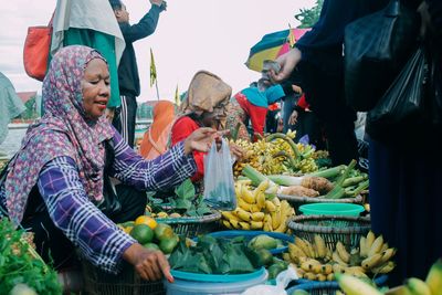 People buying food from vendors in city