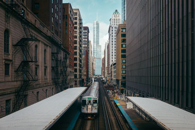 Railroad station amidst buildings in city against sky