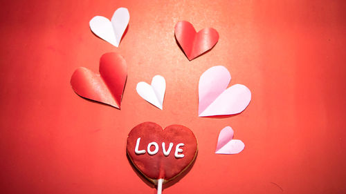 Close-up of heart shape made on red wall