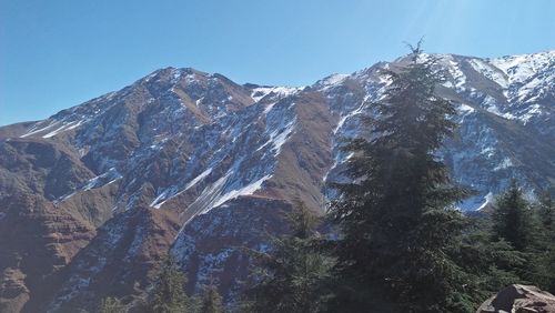 Scenic view of snowcapped mountains against clear blue sky