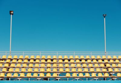 Low angle view of street lights against clear blue sky