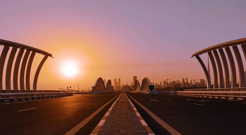 View of bridge and buildings against sky during sunset