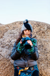 Full length of man photographing against clear sky