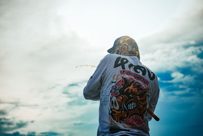 Rear view of man standing against sky