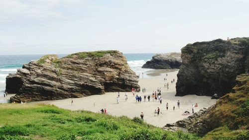 People at beach against sky