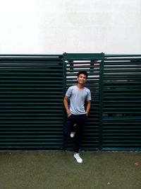 Full length of man sitting on wall against sky