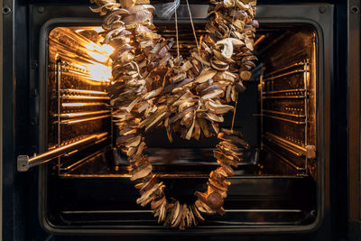 A string of mushrooms hanging by the gingerbread house. drying mushrooms strung on a thread.