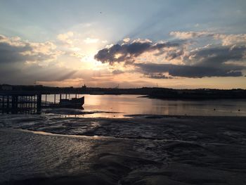 Silhouette of river against cloudy sky