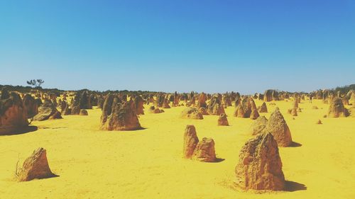 Rock formations on landscape against blue sky