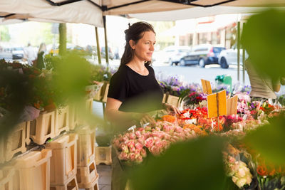 Thoughtful female owner standing at flower shop